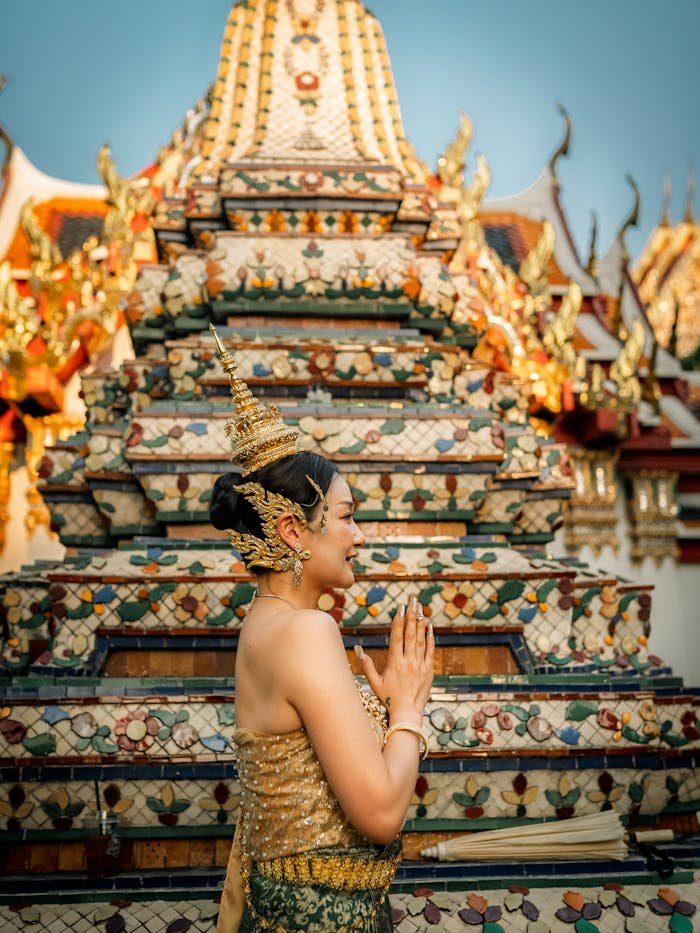 Woman in traditional Thai attire at a Bangkok temple, showcasing cultural heritage.